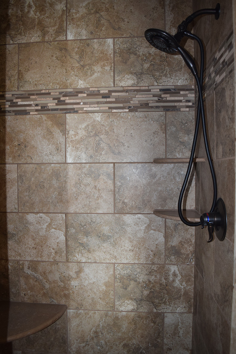 Hill Construction brown stone tiled shower stall