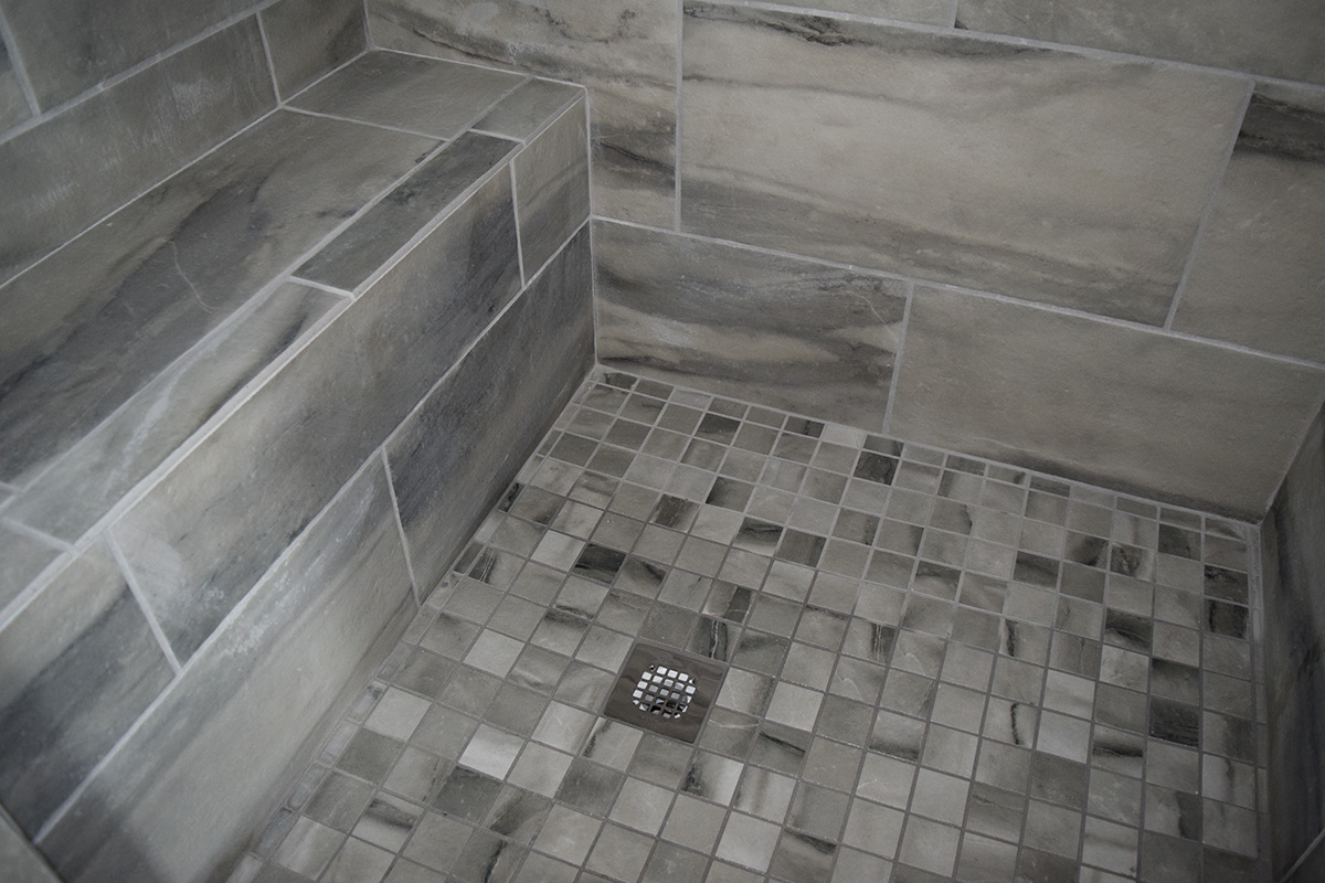 Hill Construction based in Decatur, AL gray tiled shower floor and bench.